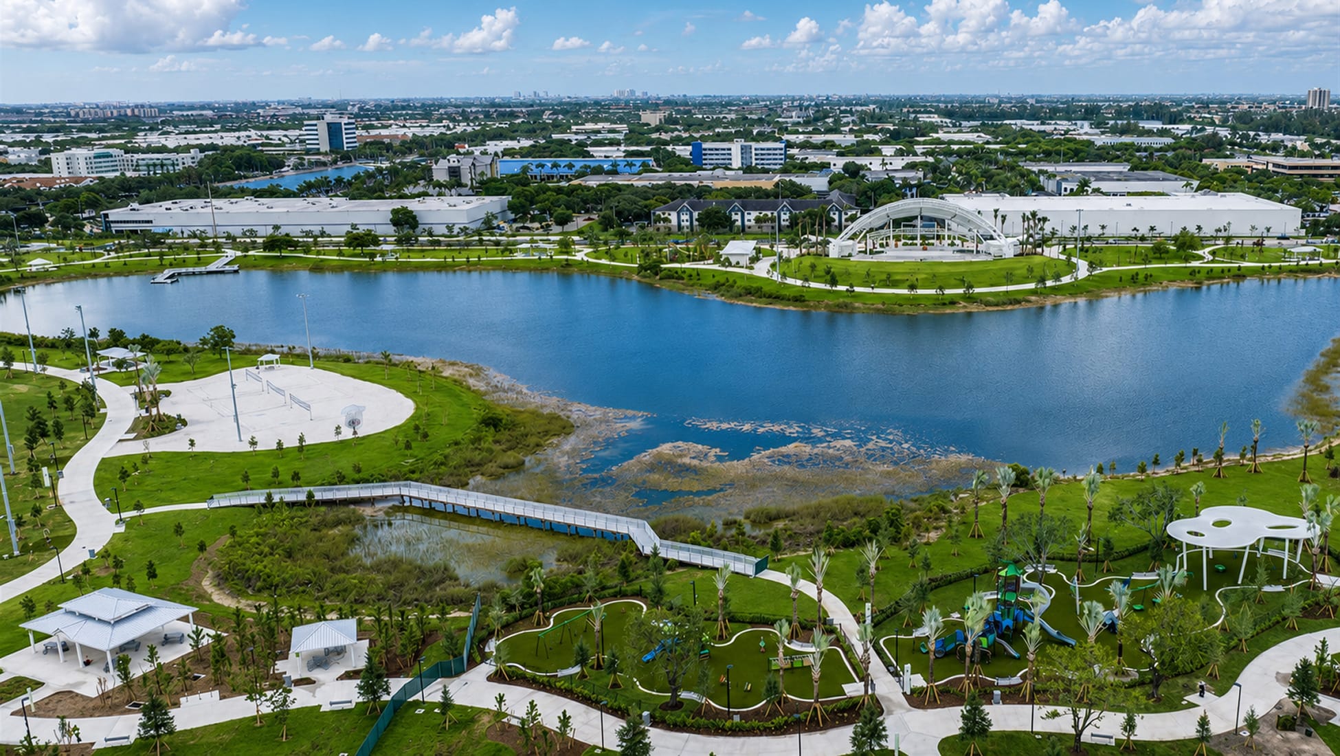 Aerial view of a lakeside public park with pedestrian paths, pavilions, and a performance venue — placemaking and wayfinding by RSM Design