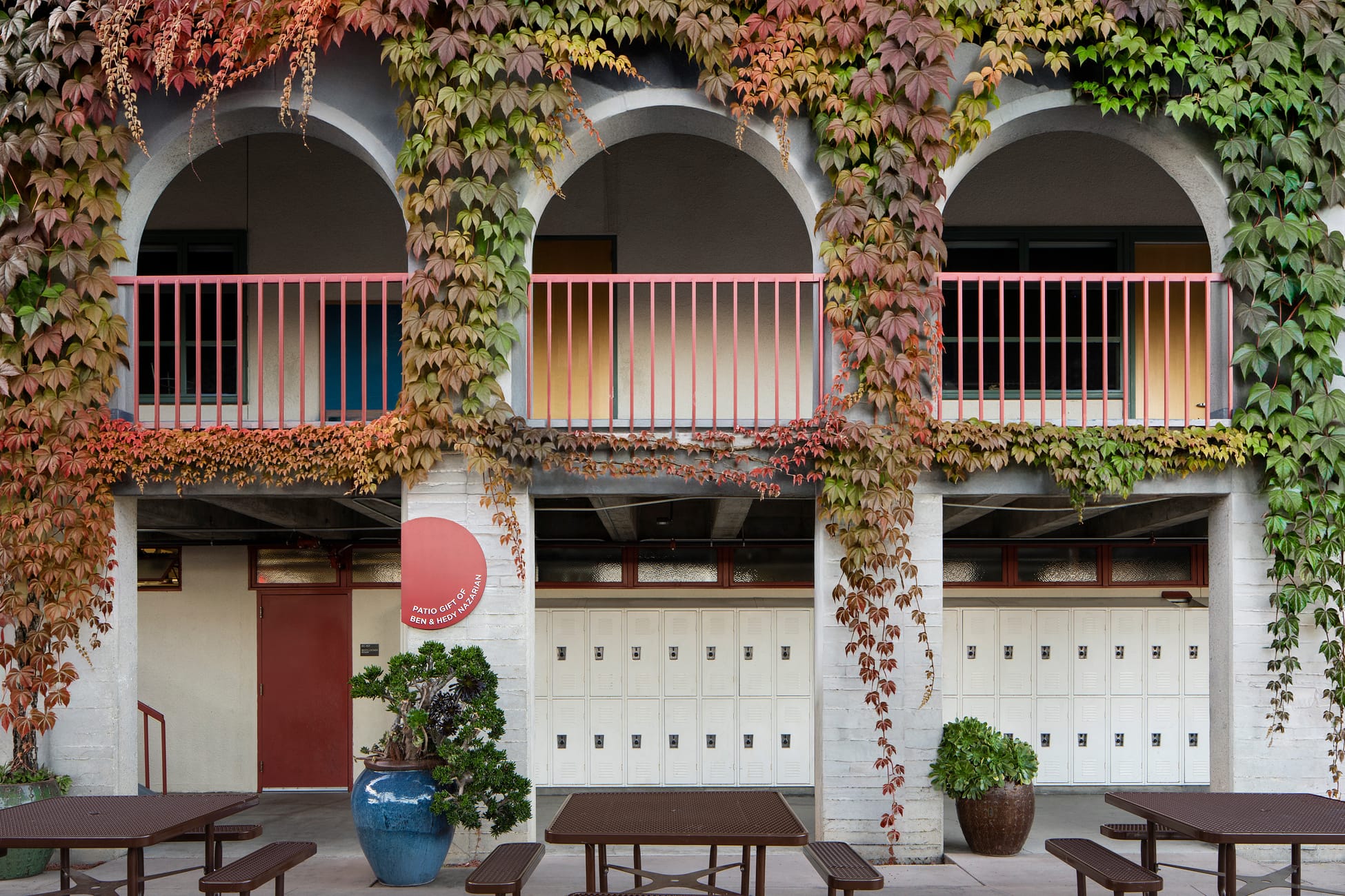 Ivy-covered archways with circular patio donor sign and student lockers at Brentwood School campus in Los Angeles - donor recognition and identity design by RSM Design