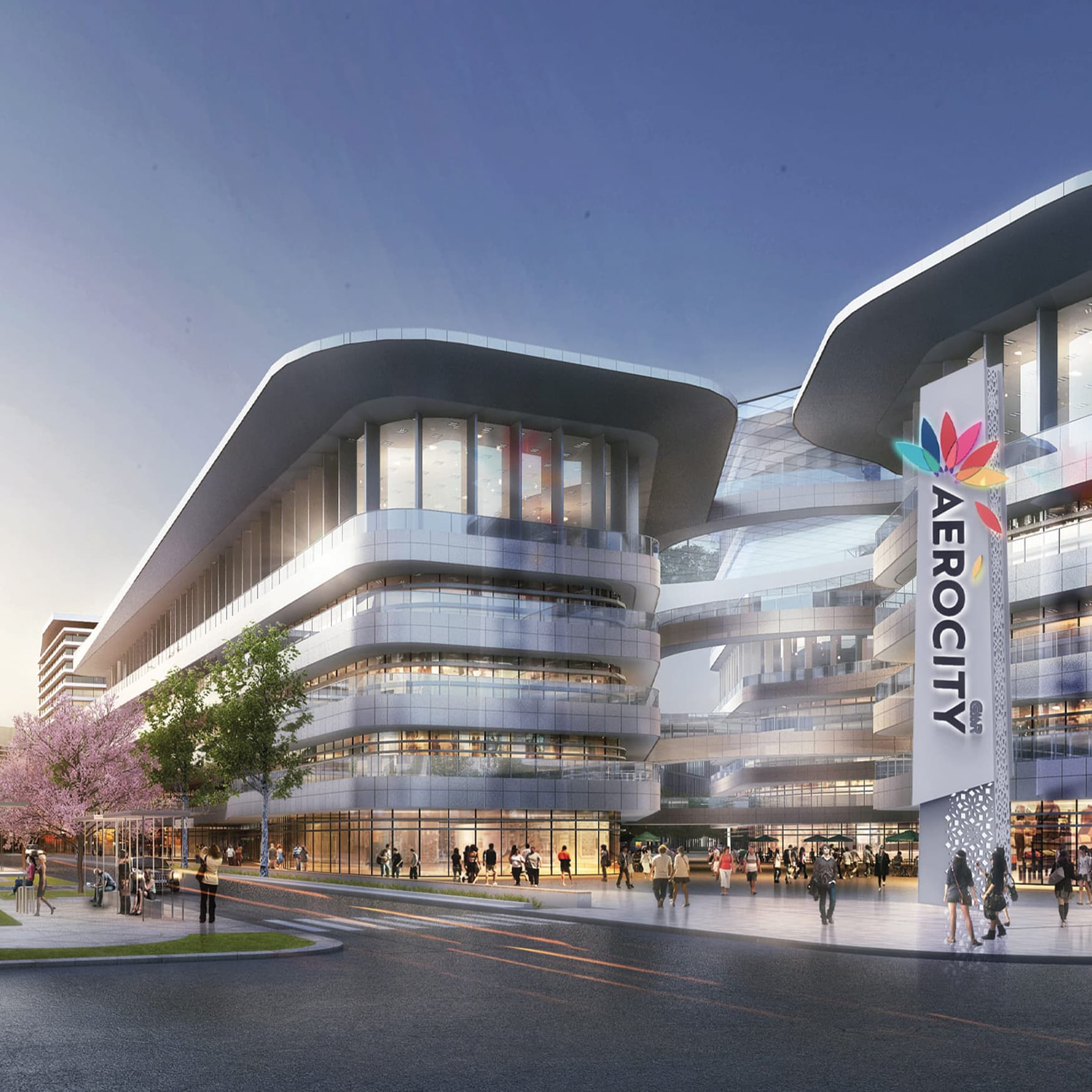 Modern mixed-use development in India featuring futuristic curved glass architecture, pedestrian plazas, connected buildings, landscaped streetscape, and a prominent vertical “AEROCITY” wayfinding sign.