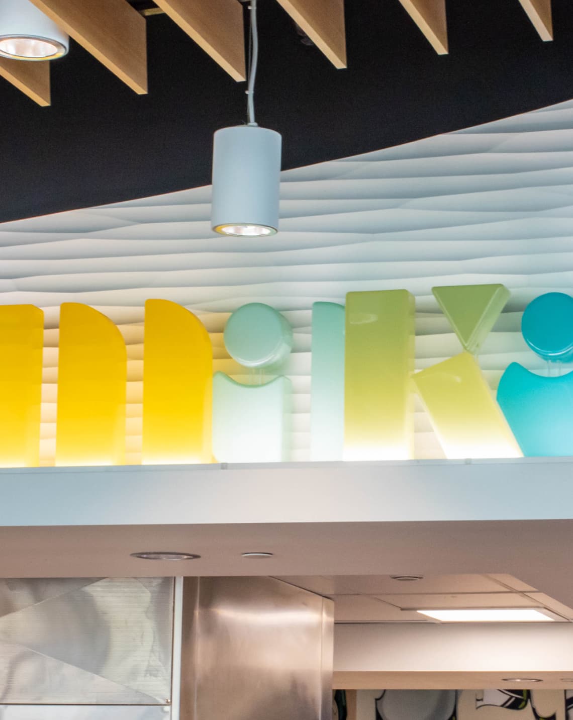 Close up of colorful resin sign identity for "Makai" in UC San Diego Sixth College's dining hall by RSM Design in San Diego, California.