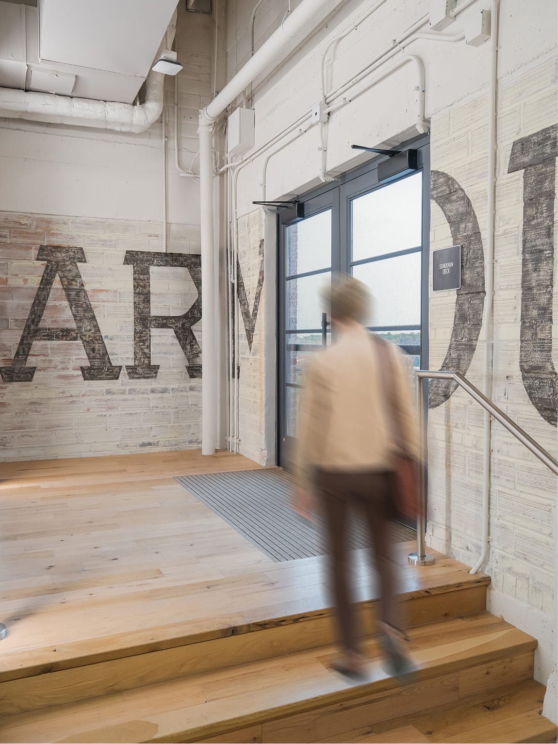 The Armour Stockyards Sundown Deck entrance with weathered brick wall lettering, environmental graphic design by RSM Design