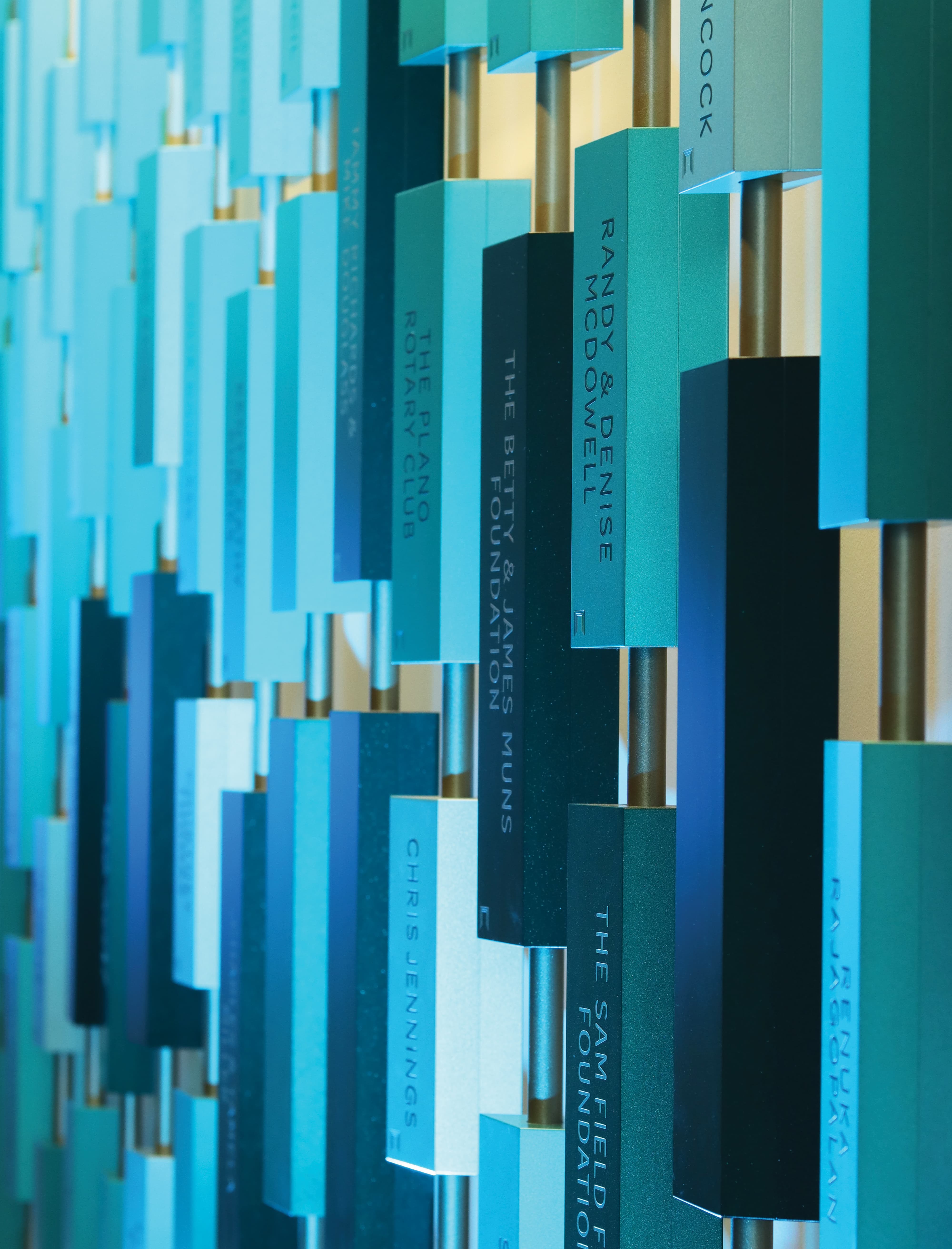 Close-up of a dimensional donor recognition installation with layered plaques and engraved donor names, showcasing environmental graphic design, experiential storytelling, and placemaking for higher education and healthcare environments.