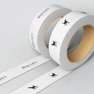 Blue Lacy Mercantile branded tape rolls featuring dog silhouette icon and logo on white tape, retail packaging and branding materials for Omni PGA Frisco gift shop