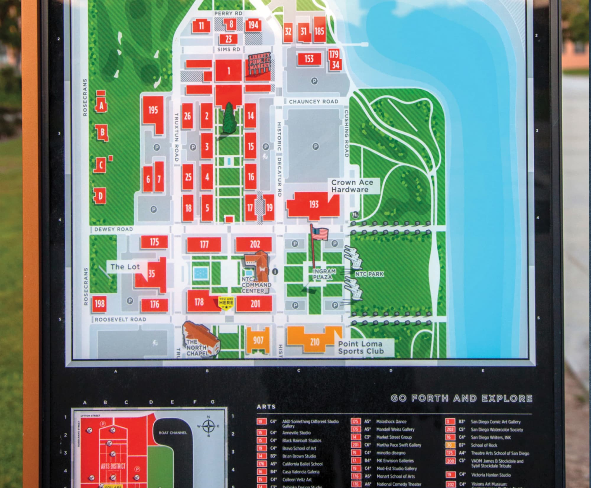 Detailed color-coded map of Liberty Station's Arts District showing numbered buildings including Liberty Public Market, NTC Command Center, and Ingram Plaza, with a green park and boat channel to the right, an arts directory list below, and a 'Go forth and explore' heading.