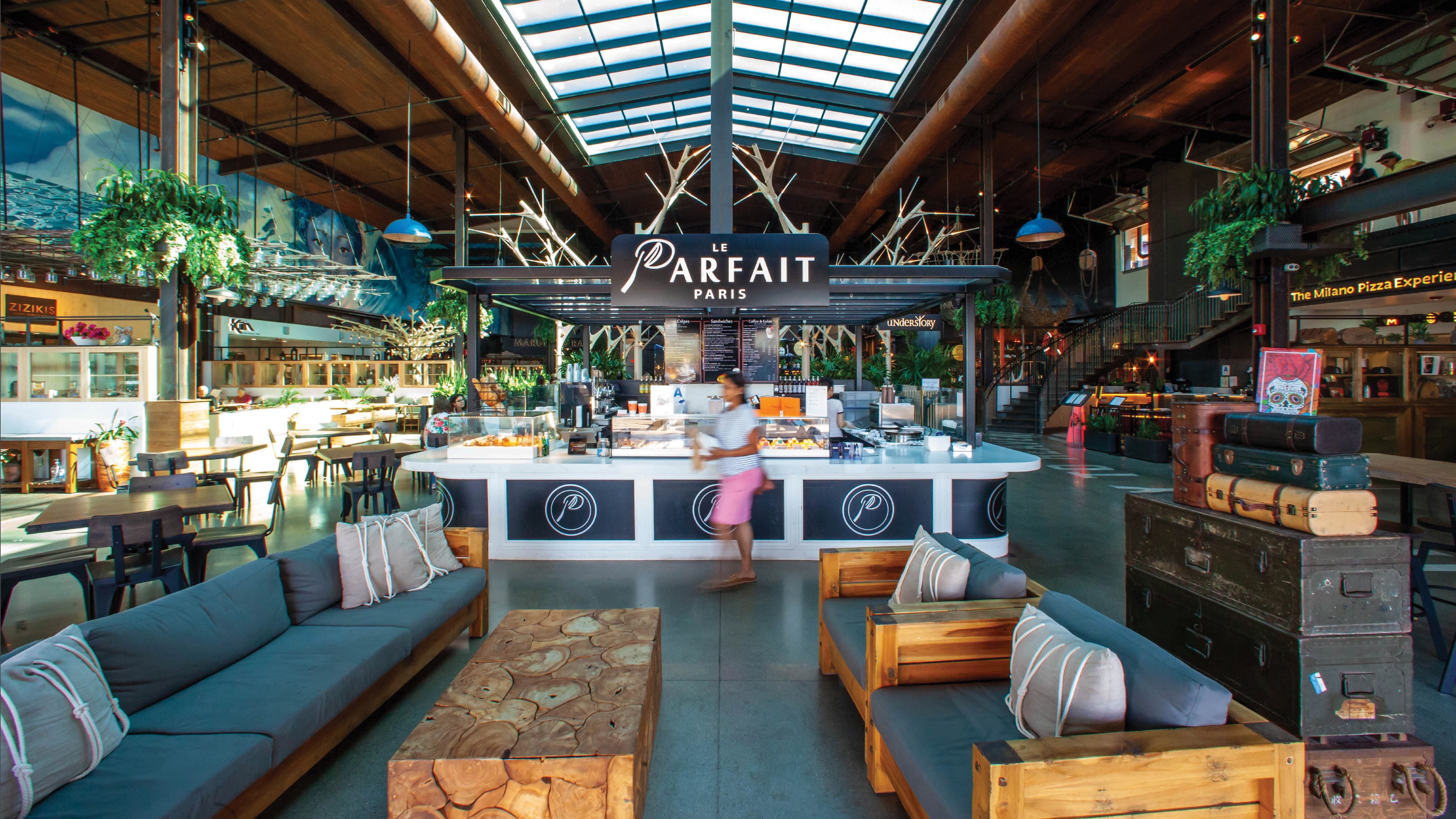 Environmental graphic design within a high-end hospitality and mixed-use food hall environment, featuring branded tenant identity for Le Parfait Paris, integrated wayfinding, and architectural graphics. The open-concept interior showcases experiential design, custom furnishings, and immersive placemaking elements that enhance guest experience, support retail and dining environments, and reinforce a cohesive brand strategy within an entertainment destination.