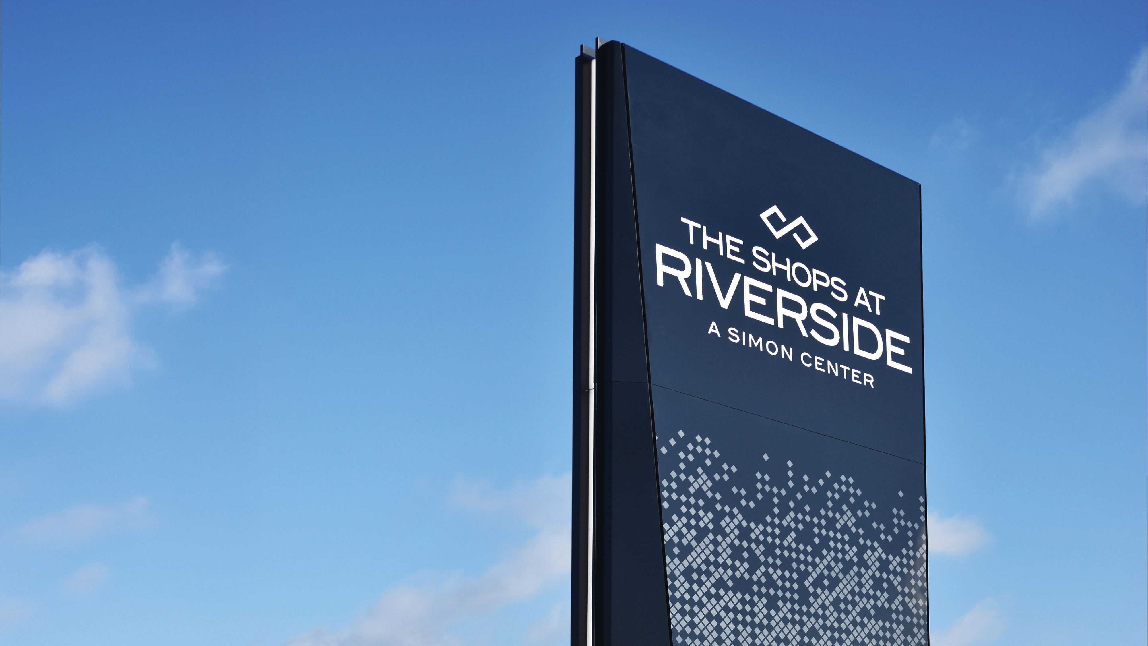 Monument signage for The Shops at Riverside, a Simon retail destination, showcasing environmental graphic design, wayfinding, and placemaking that enhance navigation and brand identity within a mixed-use retail environment.