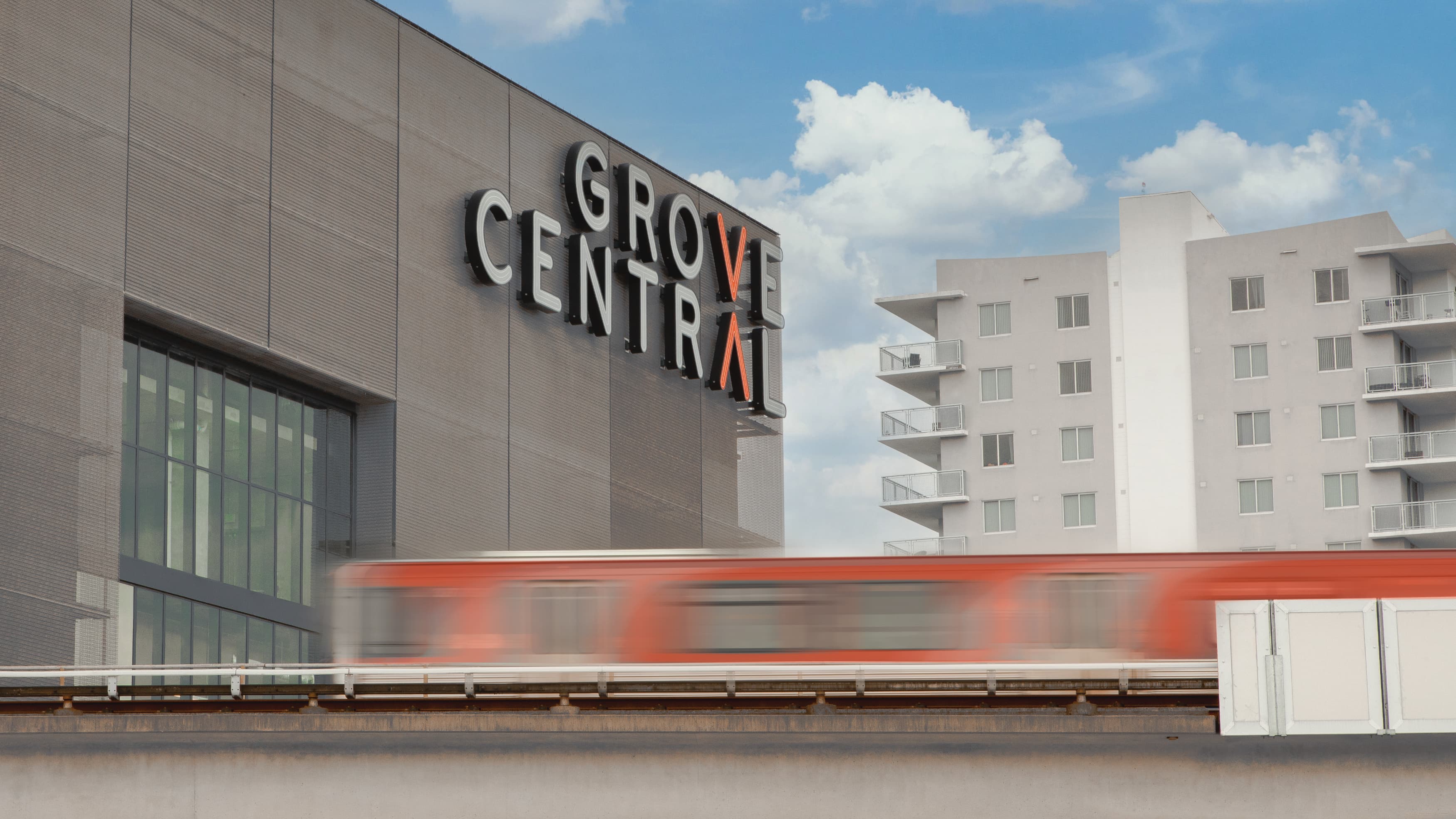 Image of the master sign for Grove Central, designed by RSM Design, along the transit tracks. 