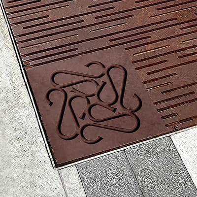 Sloan Corners brand mark embossed on a metal tree grate - environmental graphic design by RSM Design