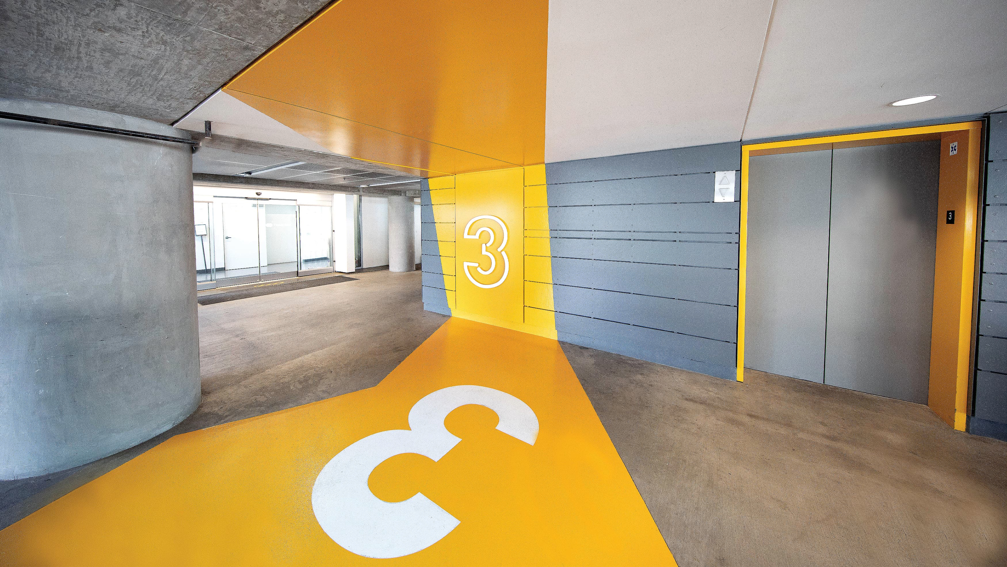 Yellow painted graphic in a parking garage with the floor number 3.