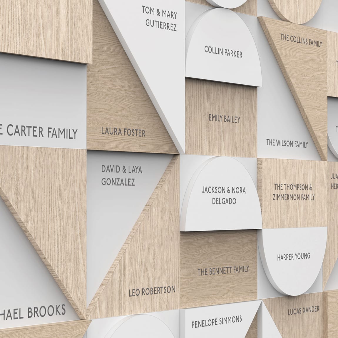 Close-up detail of the geometric wood and white donor wall, showing individual tiles engraved with names including The Carter Family, Laura Foster, Tom & Mary Gutierrez, Collin Parker, and Emily Bailey.