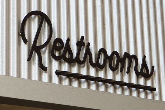 River Street Marketplace script restroom signage detail, environmental graphic design by RSM Design