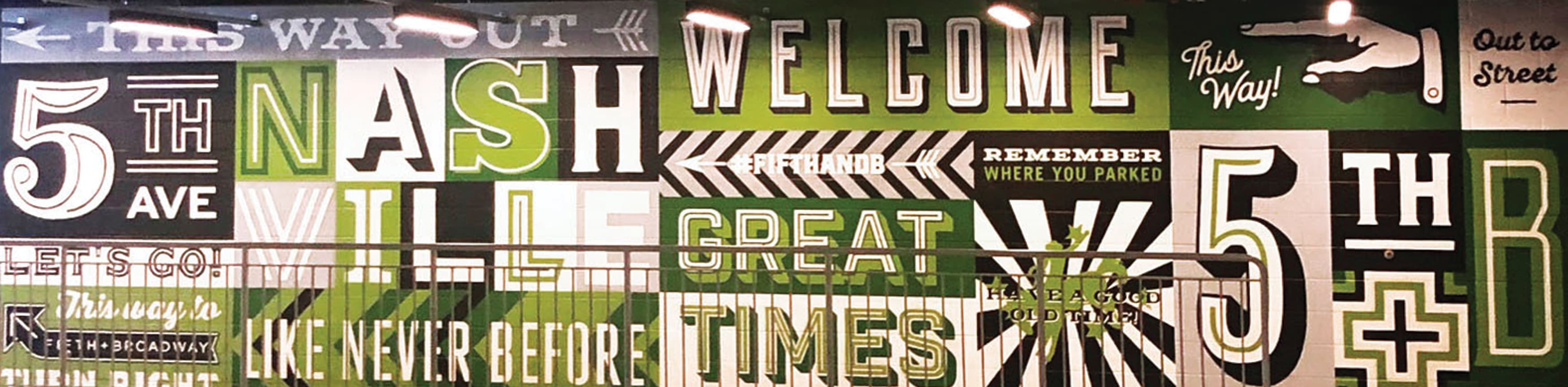 Specialty parking garage mural wall in color blocks of green, black and white with directional graphics to Fifth + Broadway. Signage and wayfinding for Fifth + Broadway in Nashville, Tennessee by RSM Design