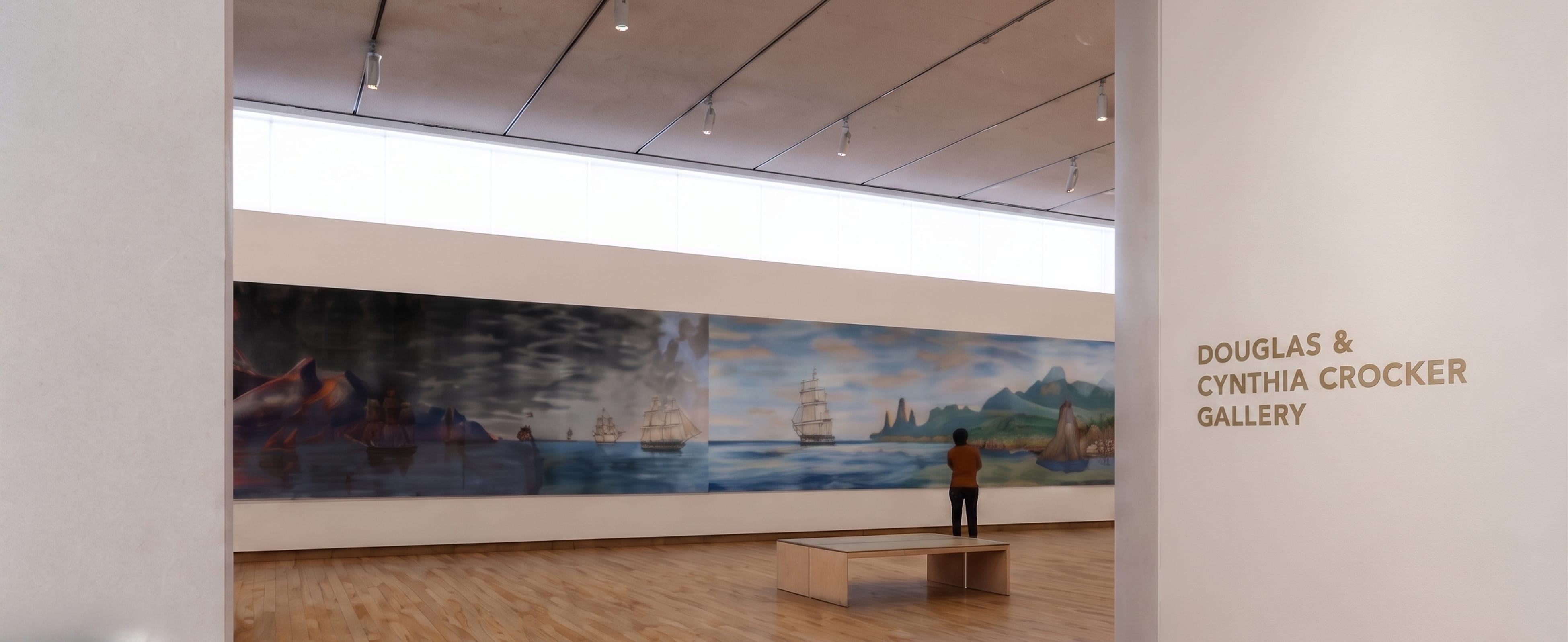 Bronze dimensional lettering reading "Douglas & Cynthia Crocker Gallery" at a gallery entrance, with a whaling ship mural visible beyond, donor recognition signage by RSM Design