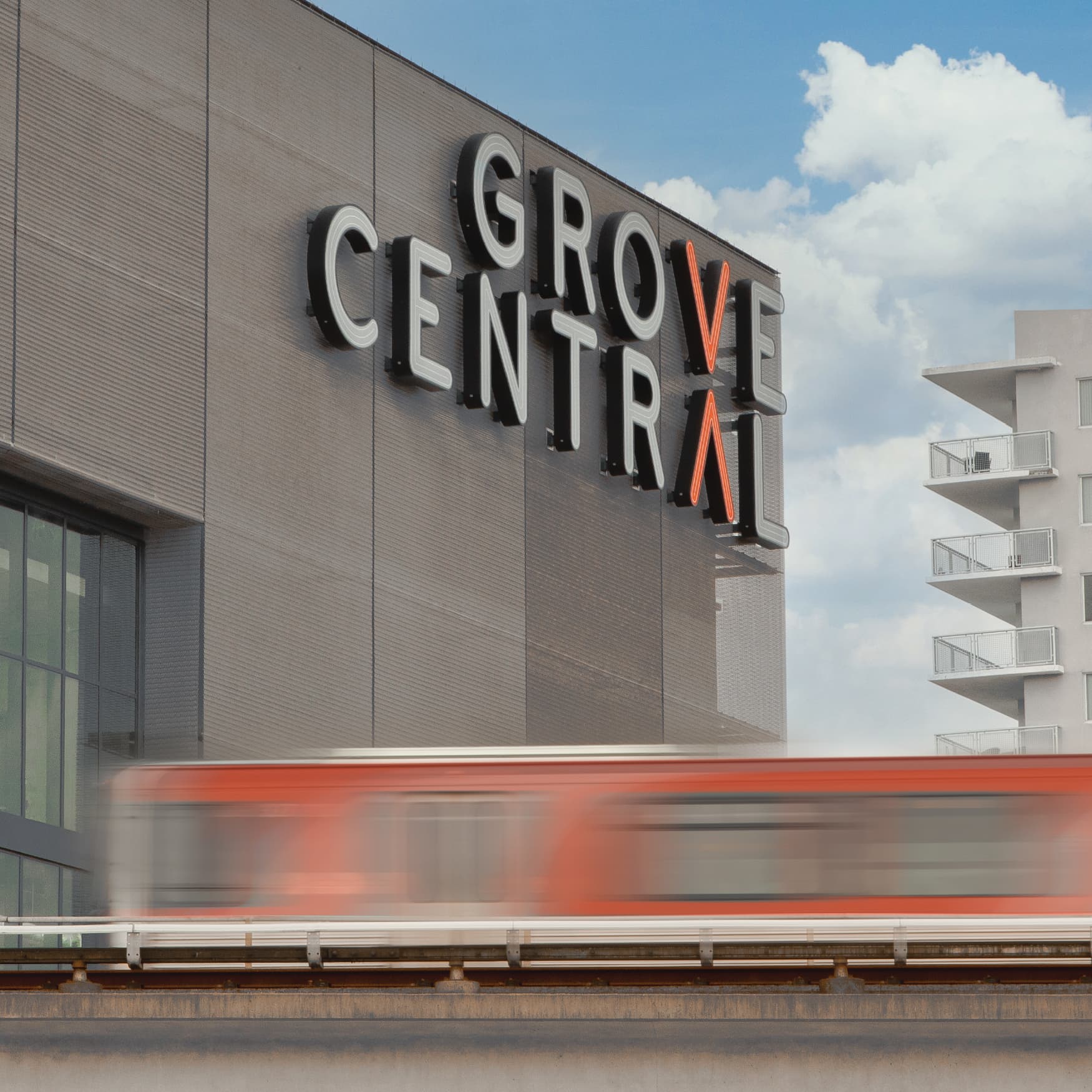 Image of the master sign for Grove Central, designed by RSM Design, along the transit tracks. 