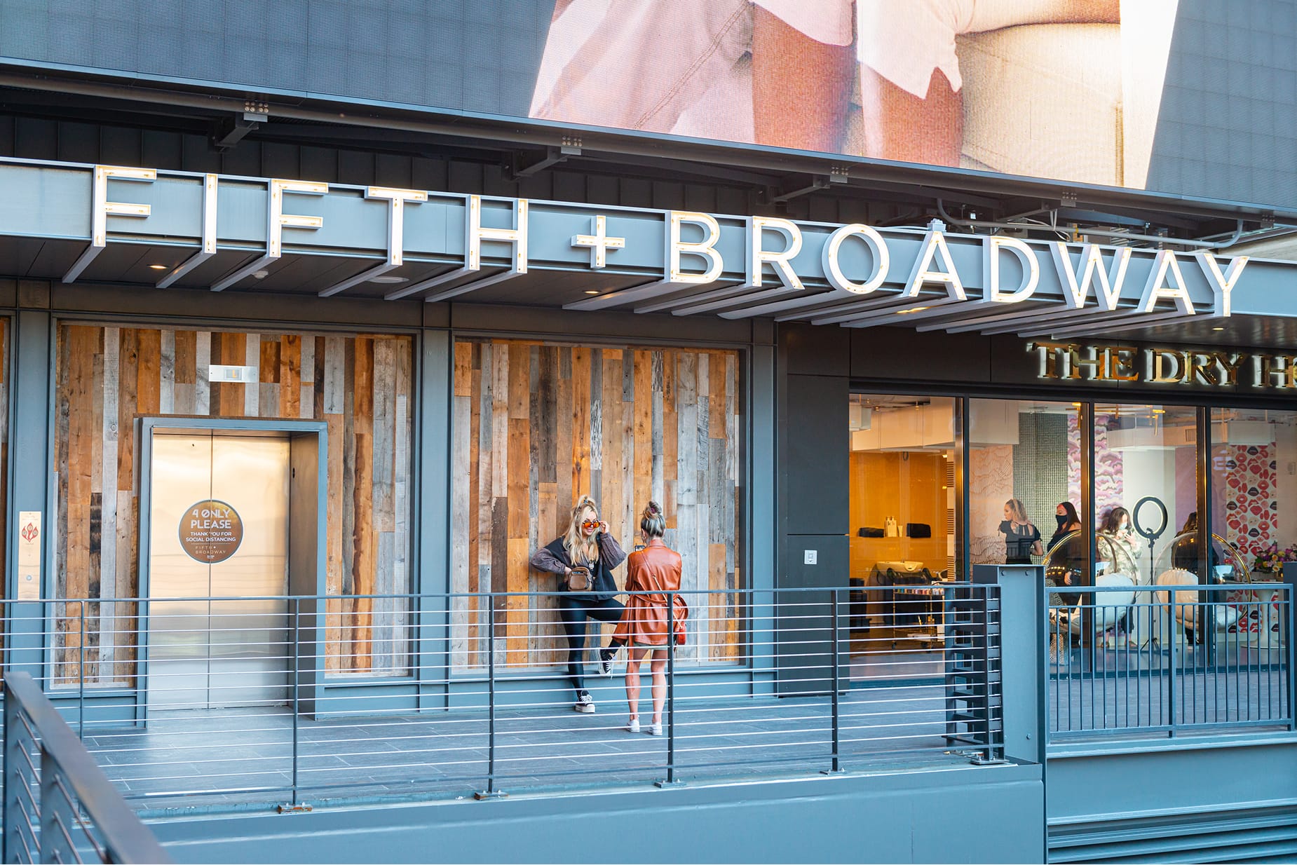 A refined storefront identity balances bold signage with warm materiality, creating an inviting threshold that draws people in while reinforcing the district’s contemporary character.