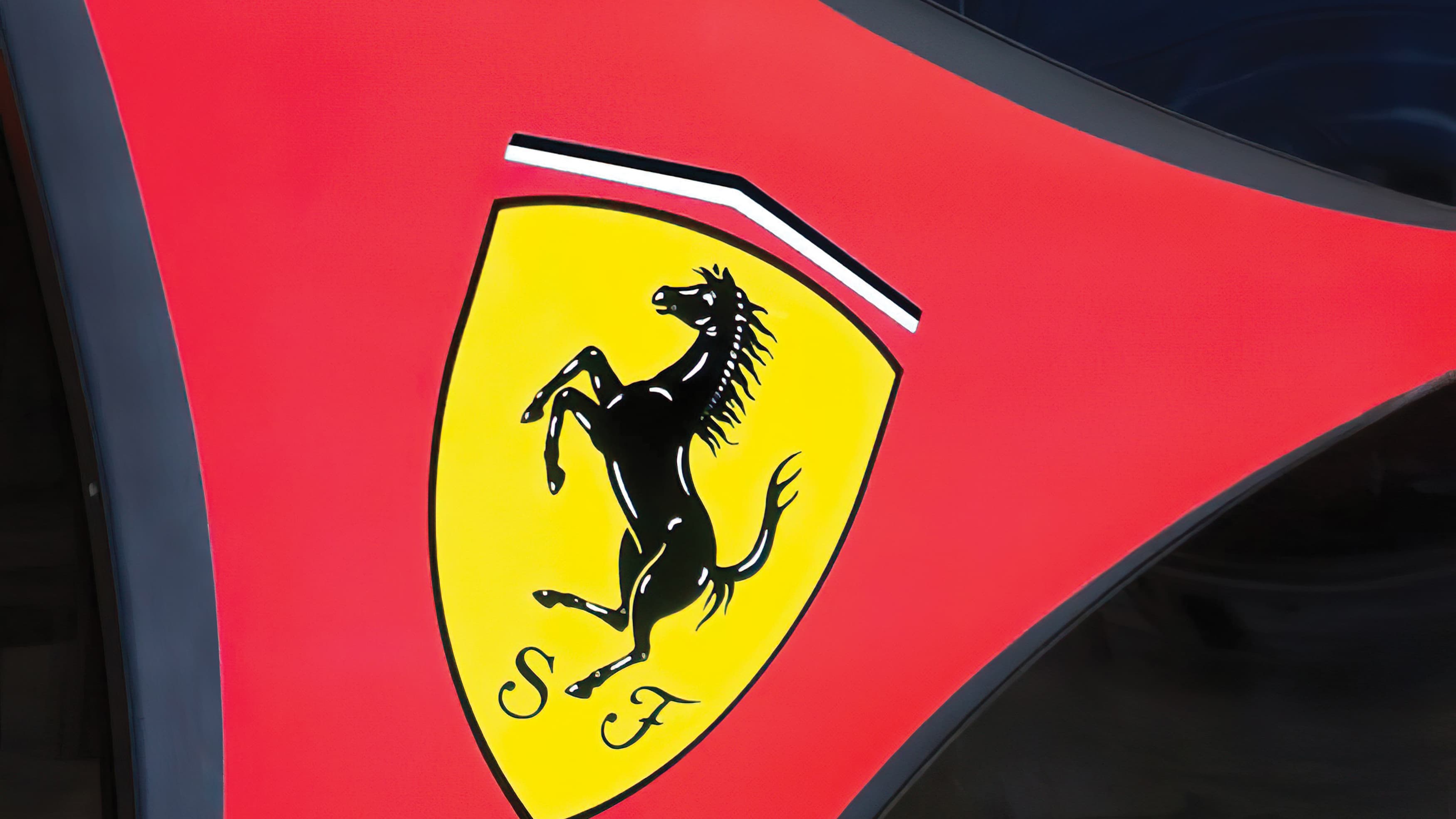 A close up of the Ferrari crest internally illuminated at night