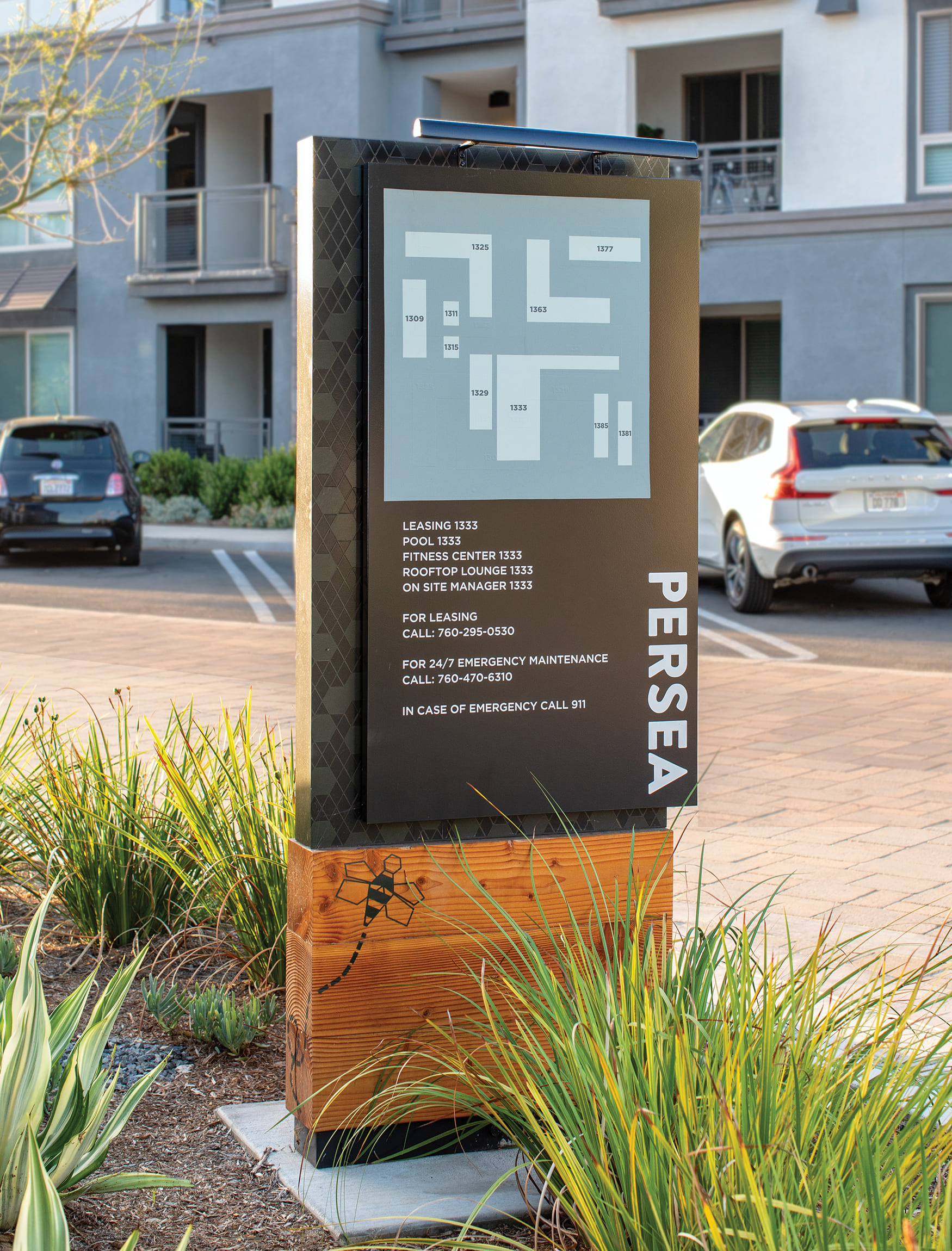 Black horizontal plaque with visible fasteners and white Persea logo and text. Signage and wayfinding for Persea in San Diego, California by RSM Design