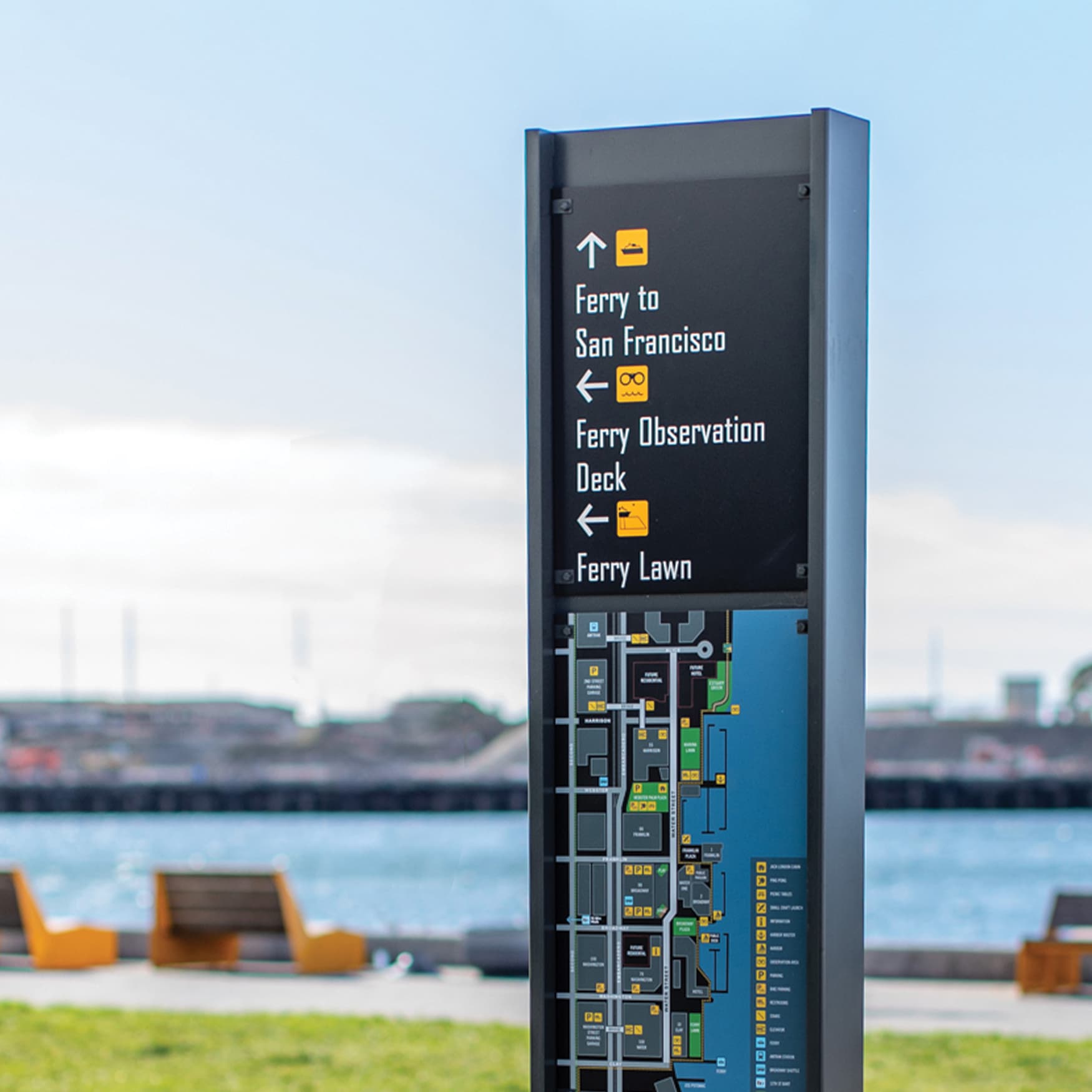 Waterfront Wayfinding Signage with Oakland Harbor and waterfront seating in the background