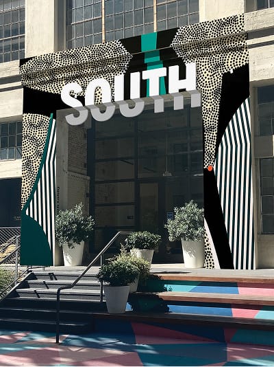 South entrance archway with bold graphic patterns and painted steps at ROW DTLA - environmental graphic design by RSM Design