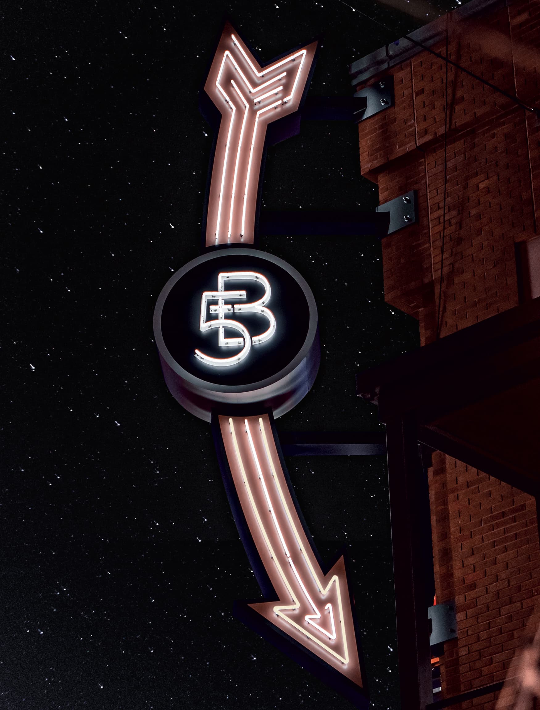 Closeup image of the Fifth + Broadway primary blade sign illuminated at night. Signage and wayfinding for Fifth + Broadway in Nashville, Tennessee by RSM Design