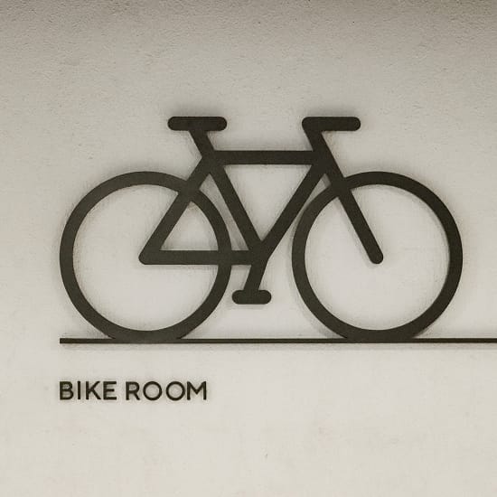Dimensional bicycle icon above a "Bike Room" sign at Maple Terrace - environmental graphic design by RSM Design