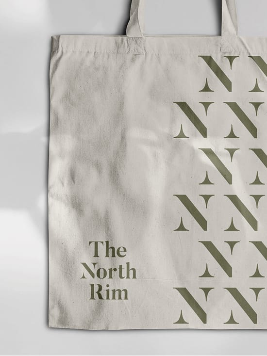 The North Rim branded canvas tote bag with repeating logo pattern, brand identity design by RSM Design