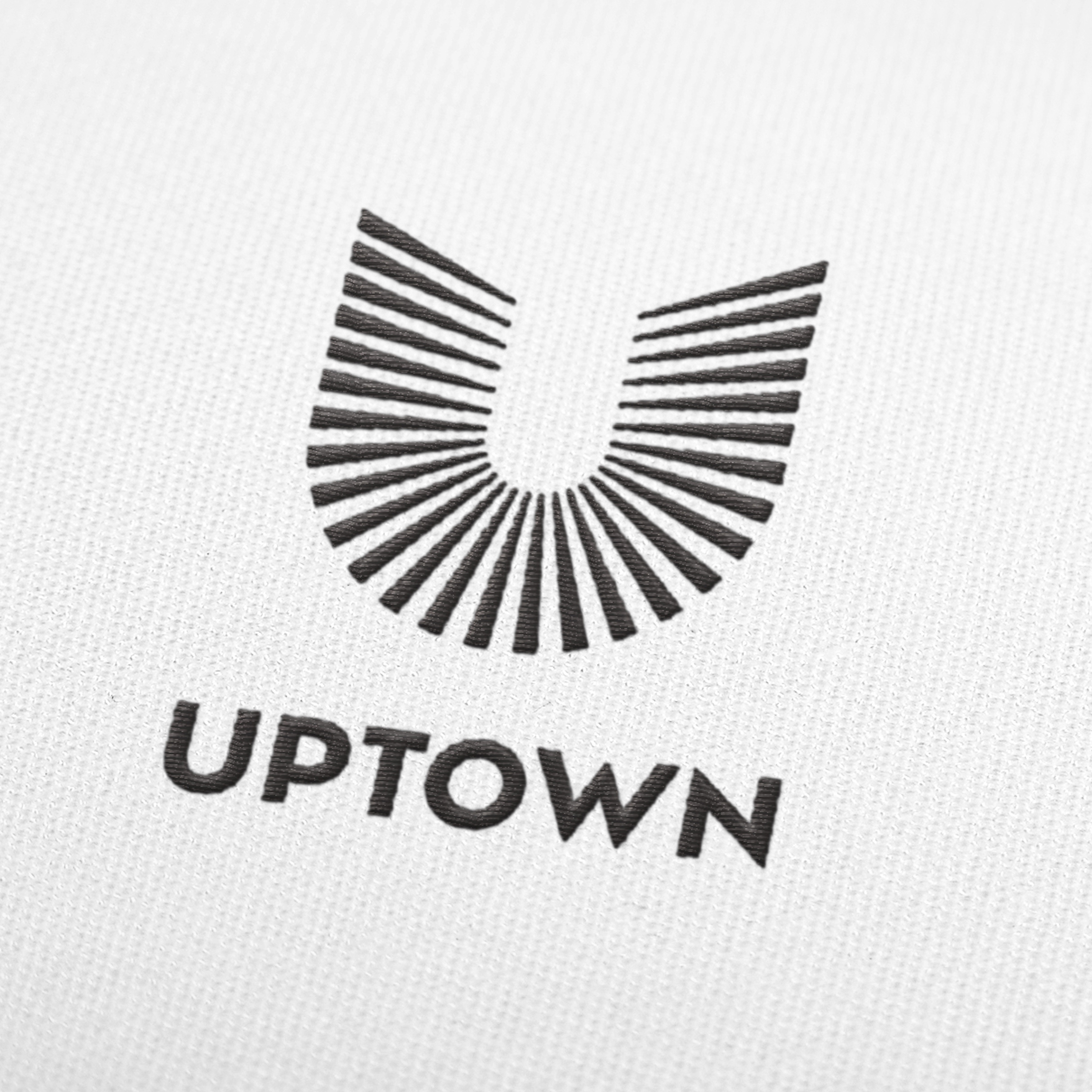 Uptown Tucson logo embroidered on white fabric, close-up brand application, branding by RSM Design