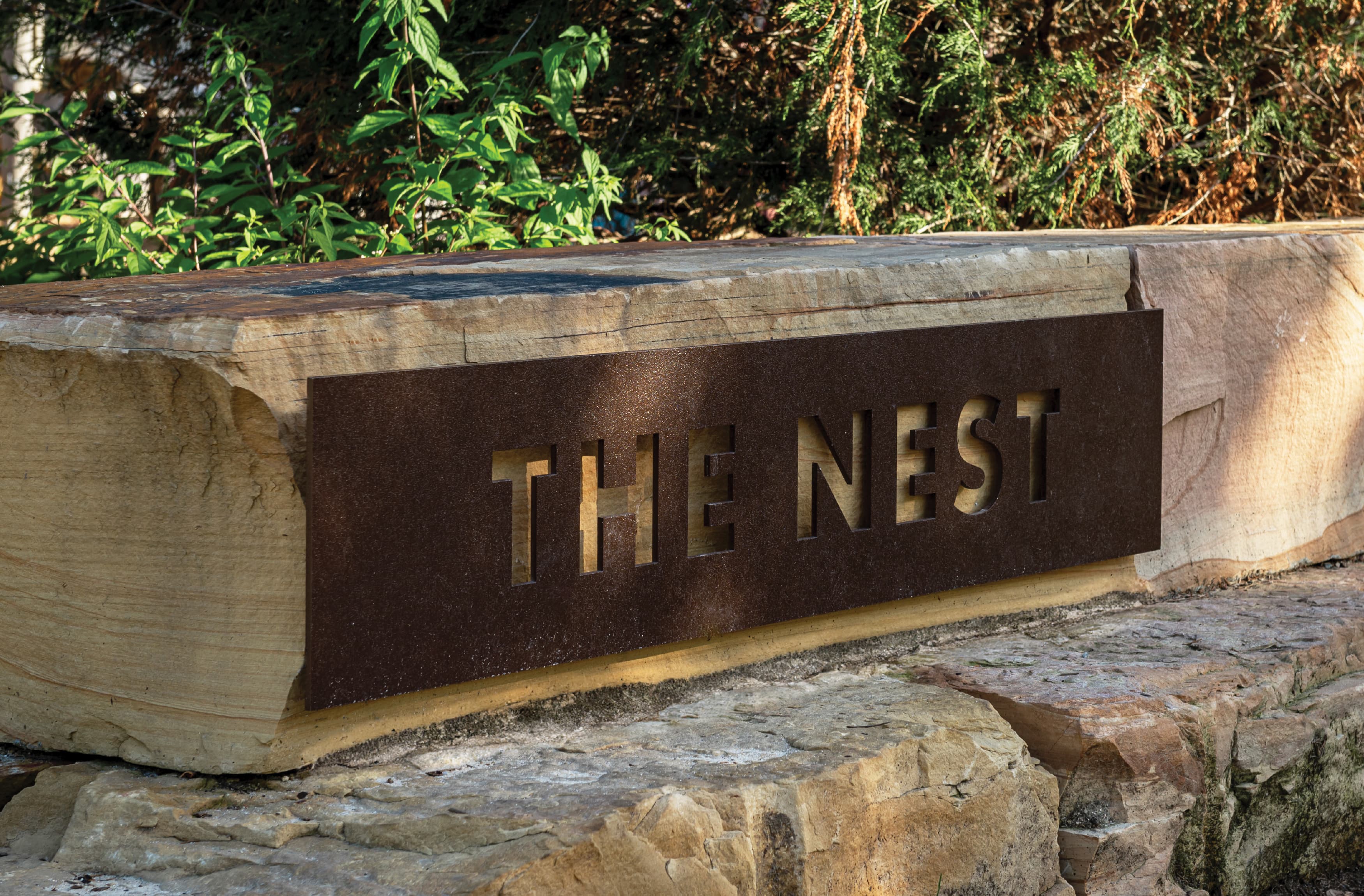 Close up detail of the Nest signage, built into a boulder at Downtown Cary Park. 