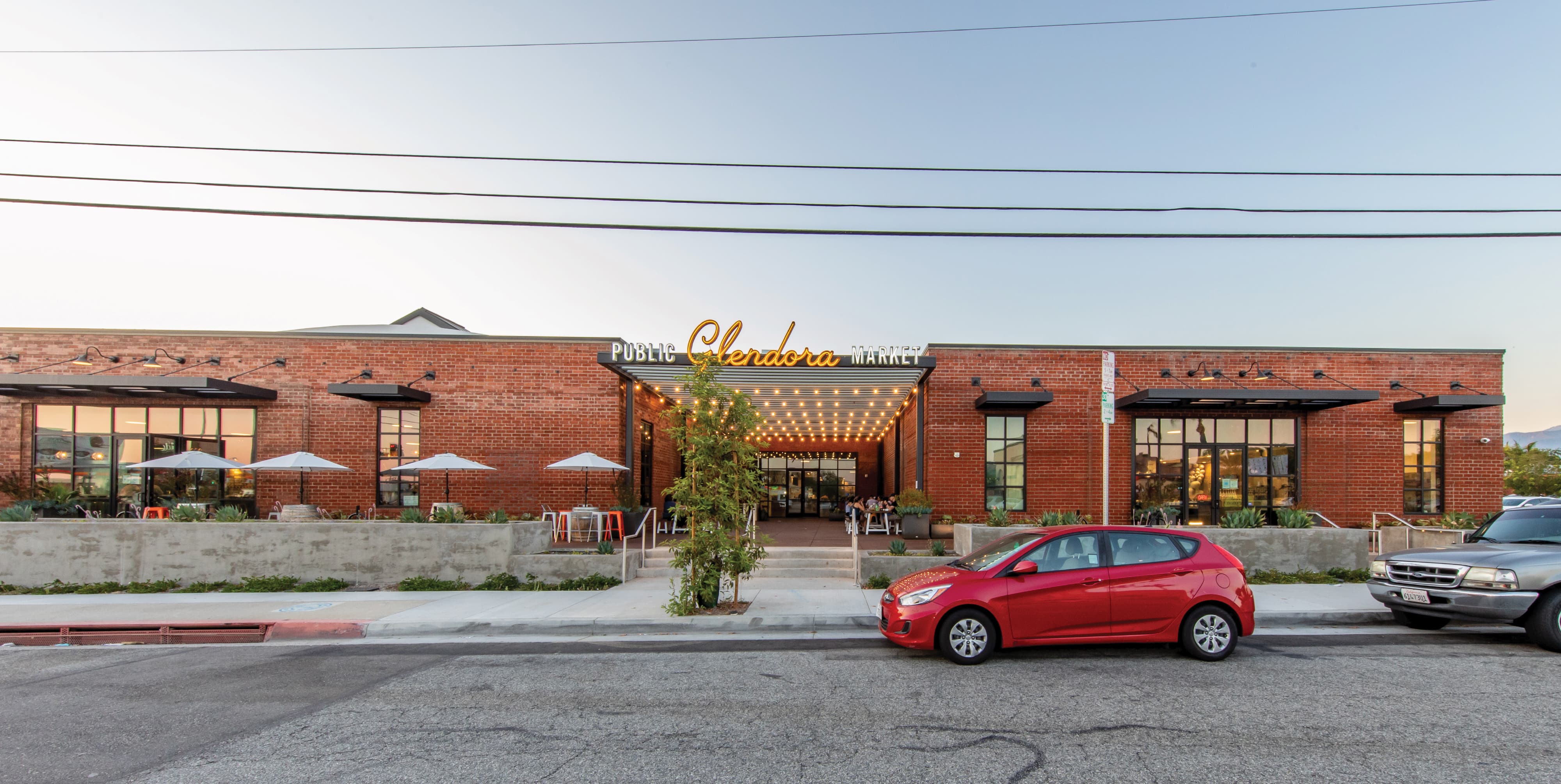 Exterior of Glendora Public Market featuring environmental graphic design, branded signage, and placemaking elements, enhancing wayfinding and user experience within a mixed-use retail and hospitality destination by RSM Design
