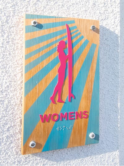 Persea residential community Womens restroom sign with surfer silhouette illustration, environmental graphic design by RSM Design