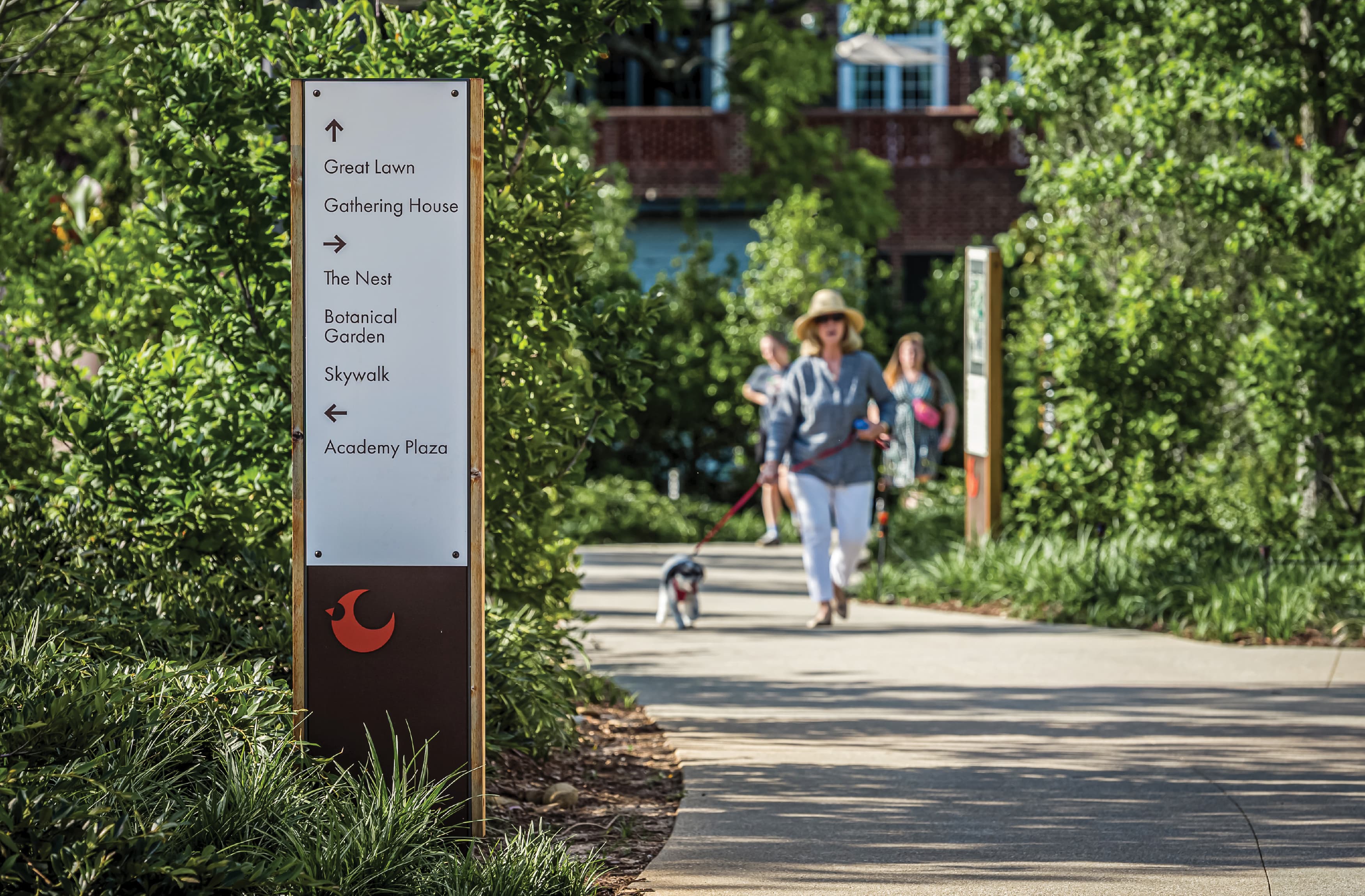 Image of the pedestrian directional at Downtown Cary Park with a woman walking by with dog. 