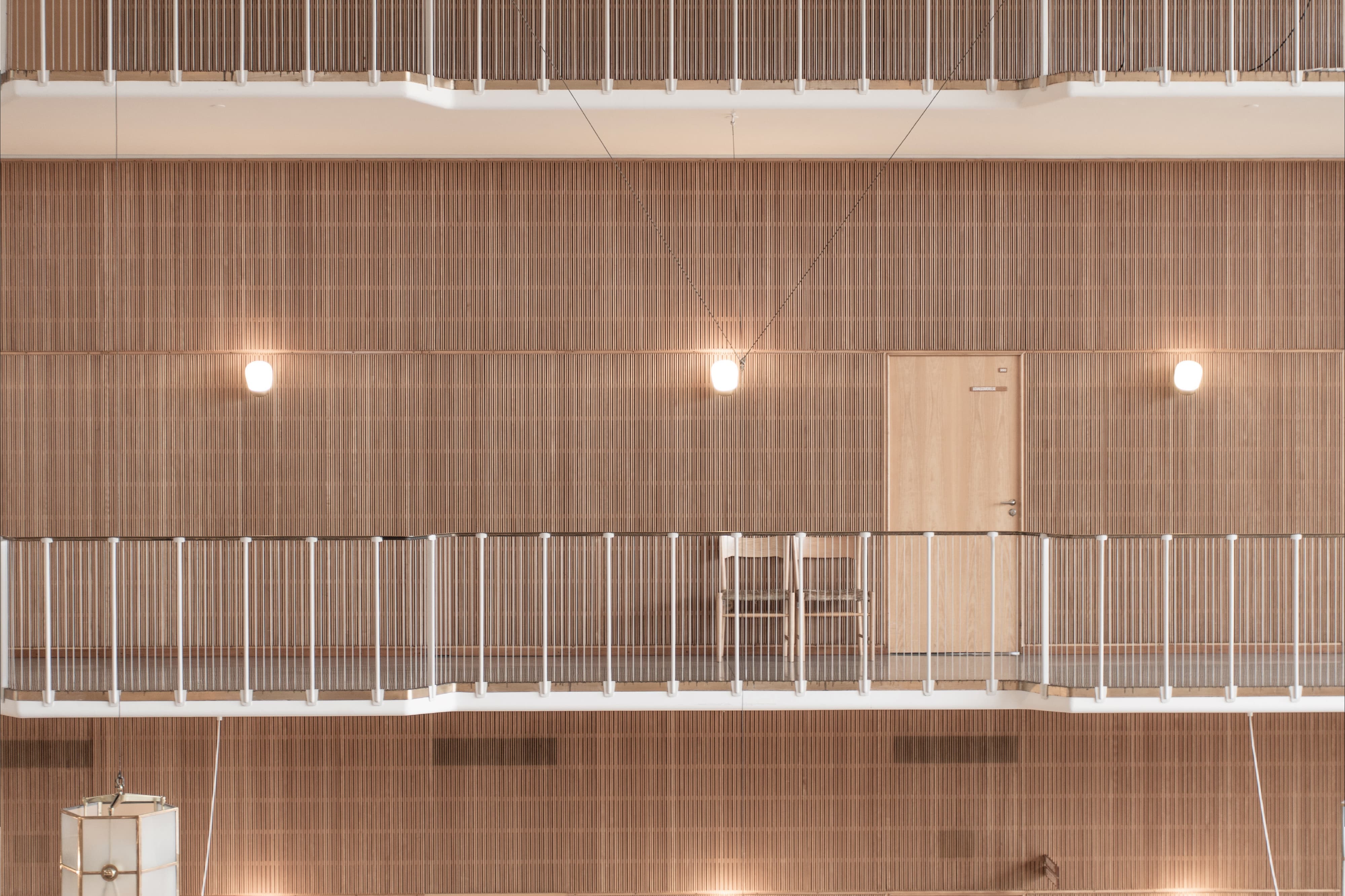 Contemporary interior architecture with layered wood slat walls, integrated lighting, and clear circulation paths, illustrating environmental graphic design and wayfinding within a civic and cultural space, reflecting RSM Design expertise in placemaking, experiential design, and identity-driven environments.