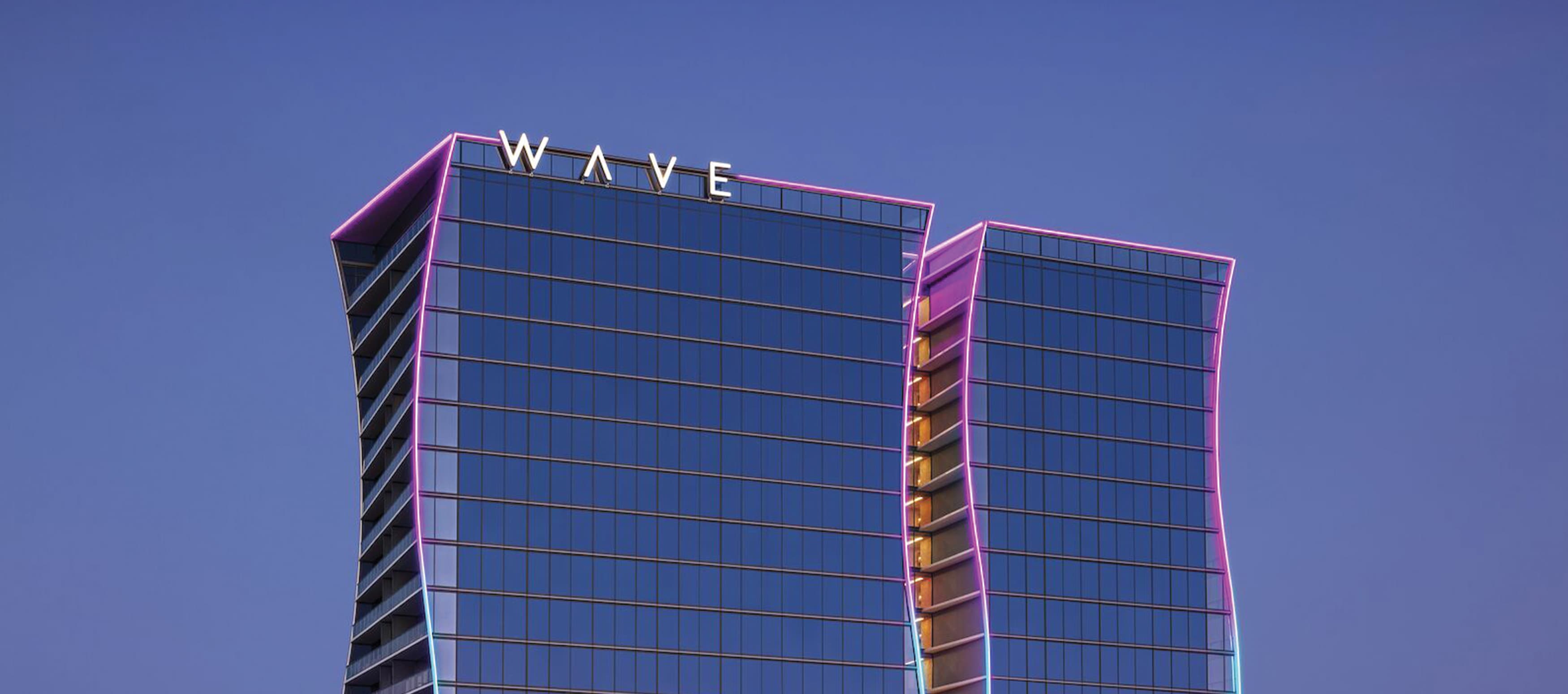 Top angle of the Wave Hotel in Orlando, Florida against a blue sky.