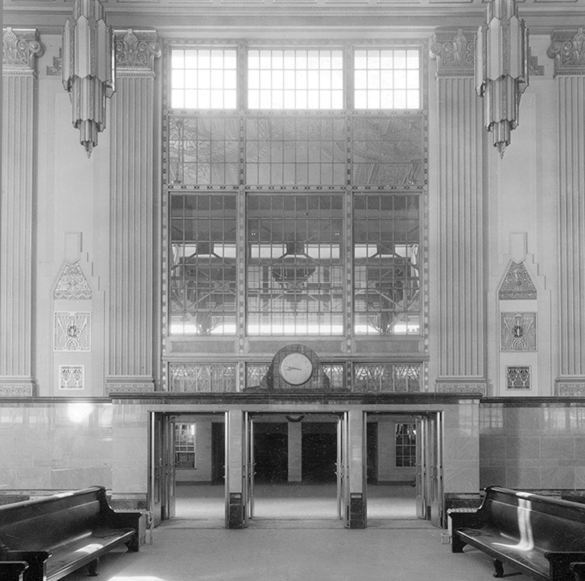 Historic black-and-white archival photograph of the T&P Station grand hall interior featuring Art Deco architecture, soaring clerestory windows, ornate columns, and a central clock, used as interpretive content for cultural placemaking and experiential graphic design at a mixed-use transit development by RSM Design.